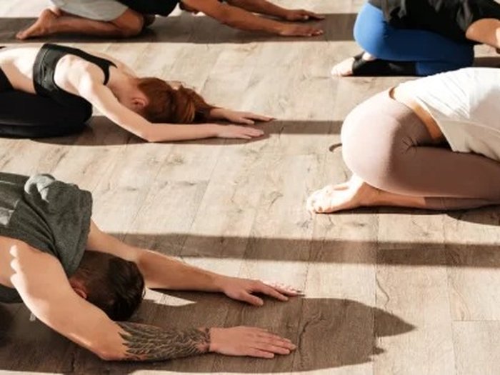 Group practicing a long-hold Yin Yoga child pose